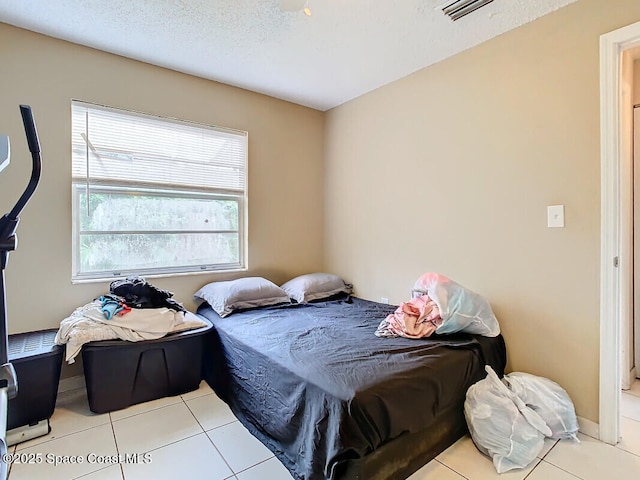 tiled bedroom with a textured ceiling