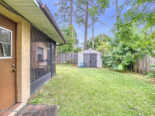 view of yard featuring a sunroom and a storage shed