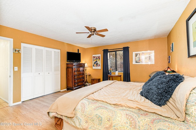 bedroom featuring ceiling fan, a textured ceiling, a closet, and light wood-type flooring