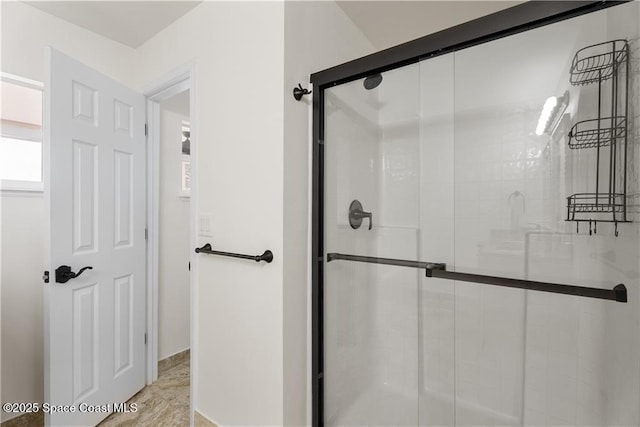 bathroom featuring a shower with door