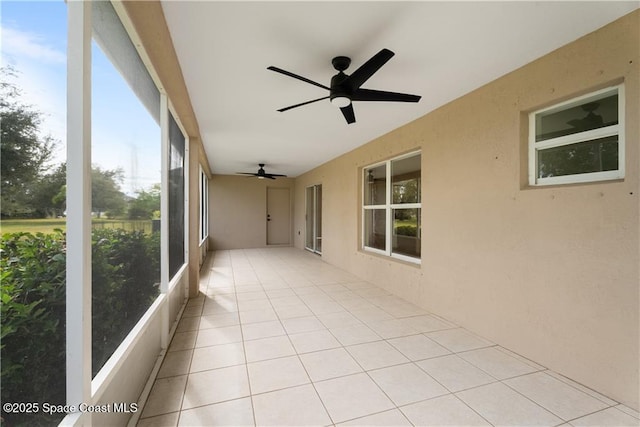 unfurnished sunroom featuring ceiling fan