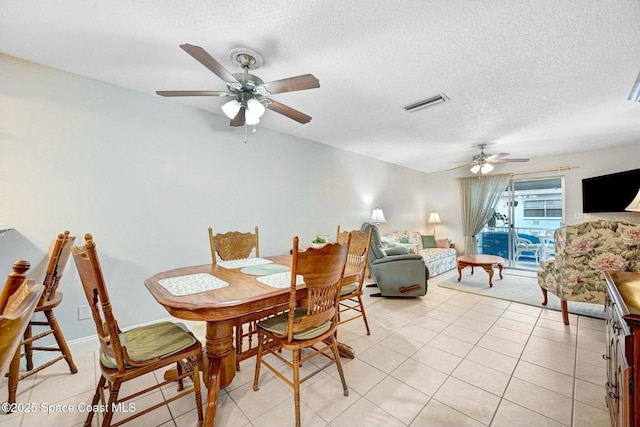 dining area featuring ceiling fan, a textured ceiling, and light tile patterned floors