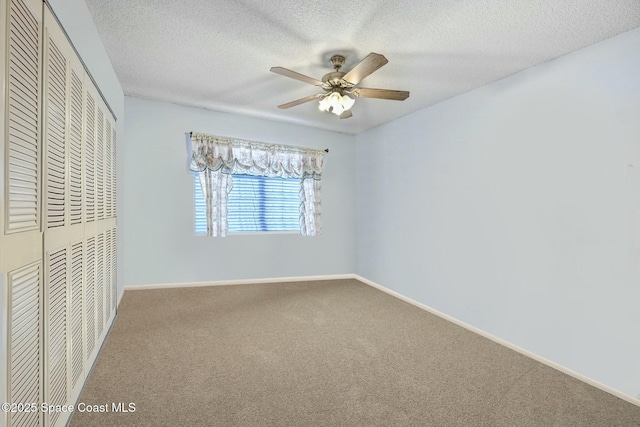 unfurnished bedroom featuring ceiling fan, a closet, carpet, and a textured ceiling