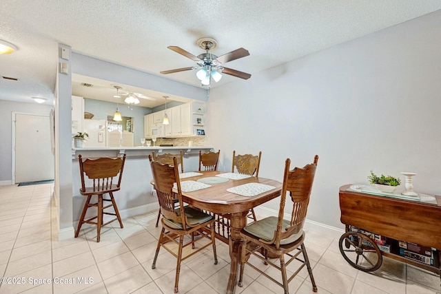 dining room featuring light tile patterned flooring, ceiling fan, and a textured ceiling