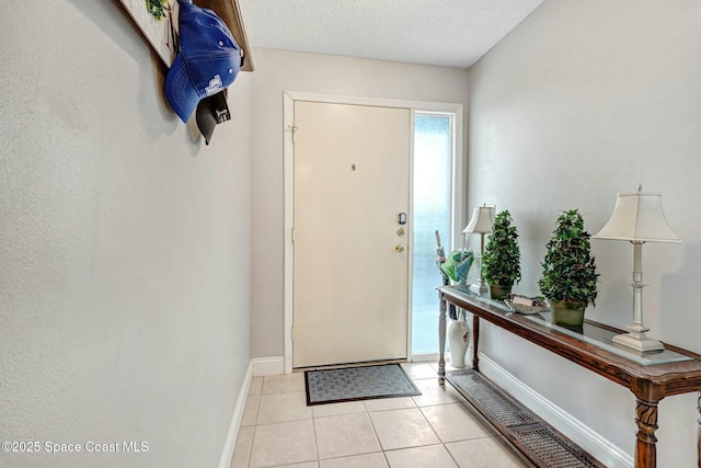 tiled foyer entrance with a textured ceiling