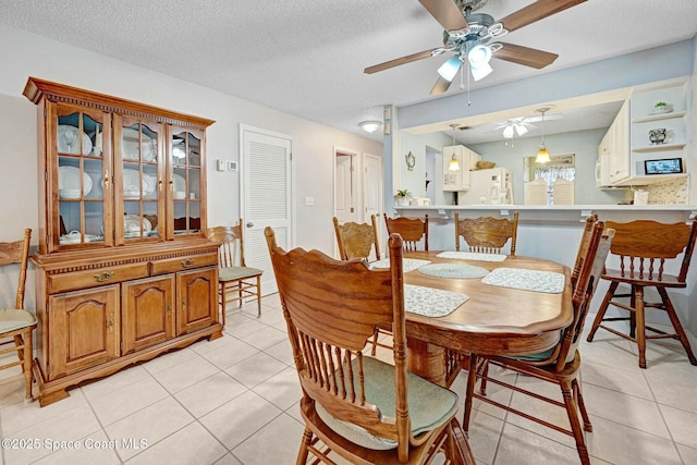 tiled dining space featuring ceiling fan and a textured ceiling