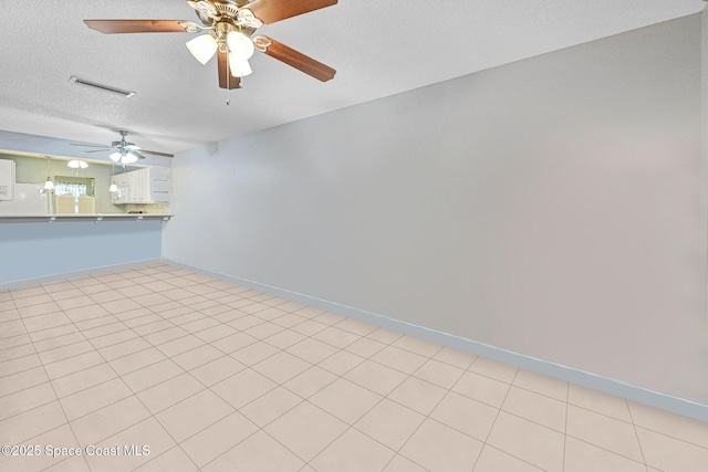 empty room with ceiling fan and a textured ceiling