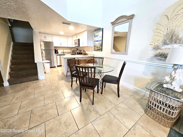 dining space with a textured ceiling