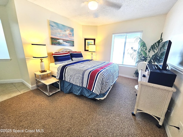 carpeted bedroom featuring a textured ceiling and ceiling fan