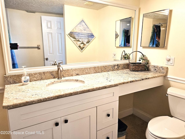 bathroom featuring vanity, toilet, tile patterned flooring, and a textured ceiling