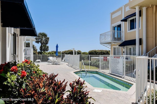 view of pool featuring a community hot tub and a patio area