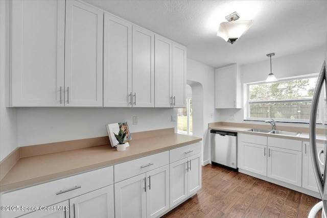 kitchen with stainless steel appliances, sink, hanging light fixtures, and white cabinets