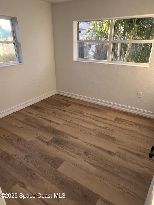 unfurnished room with dark wood-type flooring