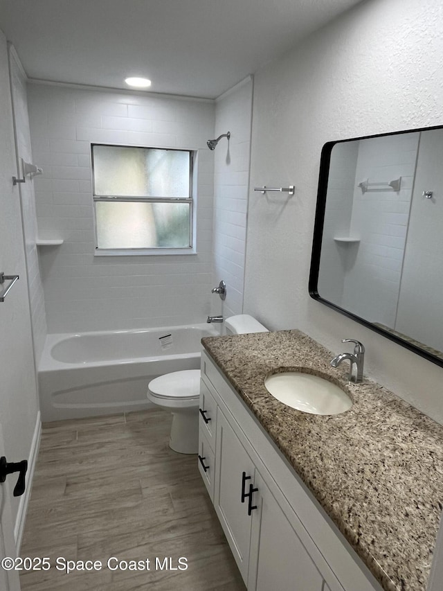 bathroom with shower / bath combination, toilet, wood finished floors, and vanity