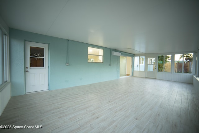 empty room featuring light hardwood / wood-style flooring and a wall unit AC