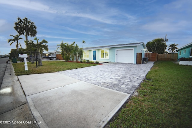 ranch-style home with a garage, central AC, and a front lawn