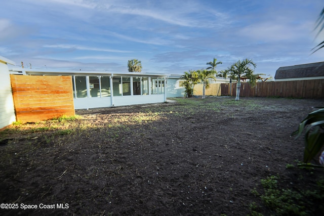 view of yard with fence and a sunroom