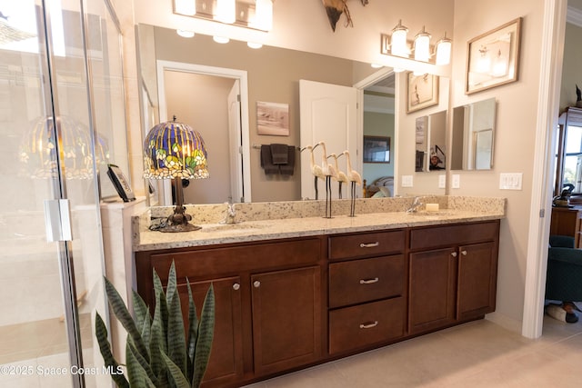 ensuite bathroom with ensuite bathroom, a shower stall, a sink, tile patterned floors, and double vanity