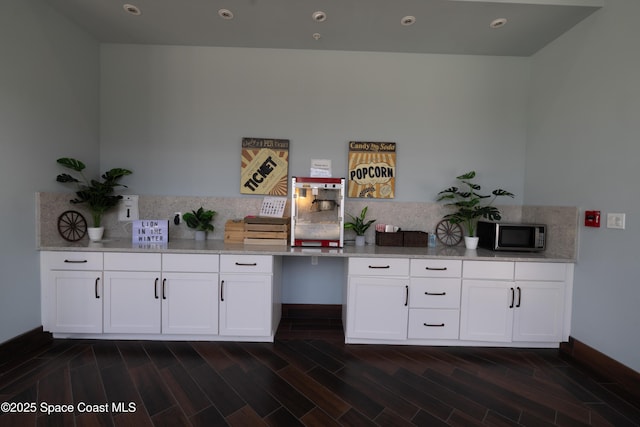 interior space with stainless steel microwave, recessed lighting, baseboards, and wood tiled floor