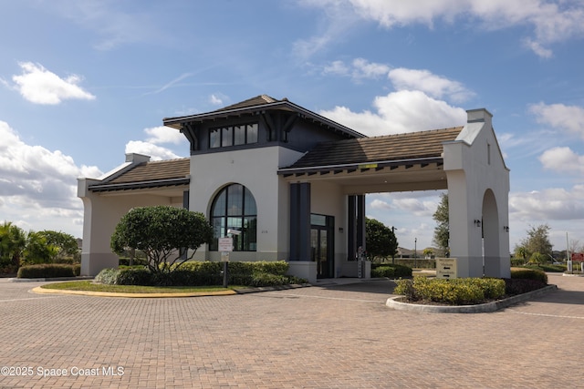 exterior space featuring stucco siding and a tile roof