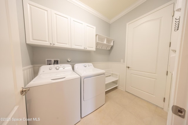 washroom with cabinet space, a wainscoted wall, separate washer and dryer, and crown molding