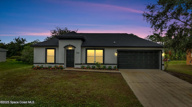 view of front of house with a garage and a lawn