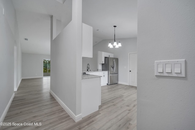 hallway featuring sink, a notable chandelier, high vaulted ceiling, and light hardwood / wood-style flooring