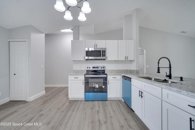 kitchen with stainless steel appliances, white cabinetry, vaulted ceiling, and sink