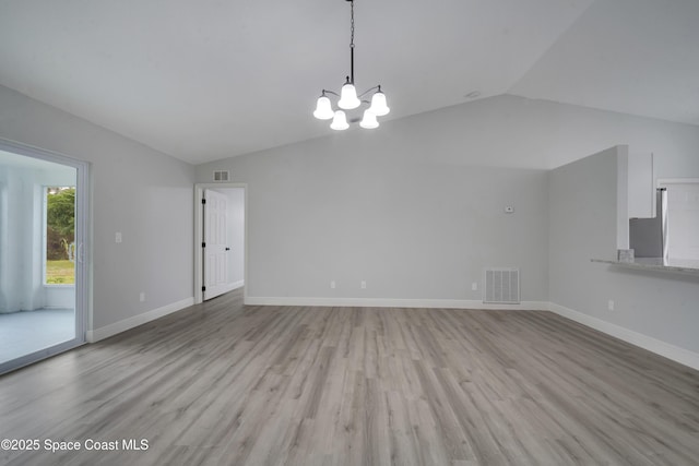 interior space featuring vaulted ceiling, an inviting chandelier, and light hardwood / wood-style flooring