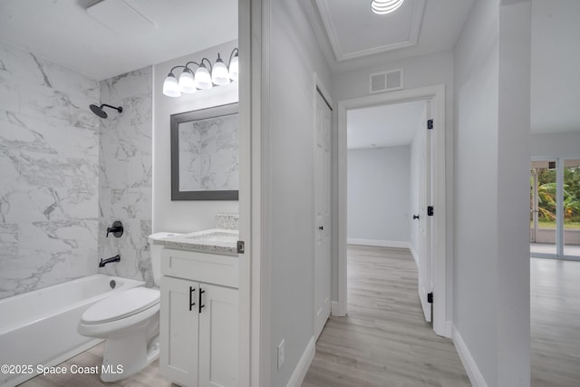 full bathroom with vanity, hardwood / wood-style flooring, toilet, and tiled shower / bath