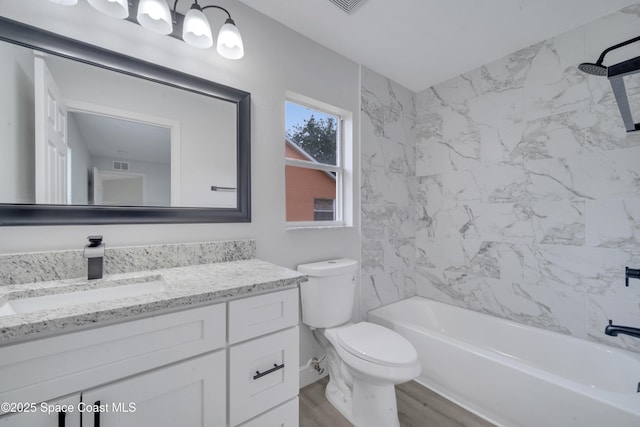 full bathroom with vanity, hardwood / wood-style floors, toilet, and tiled shower / bath