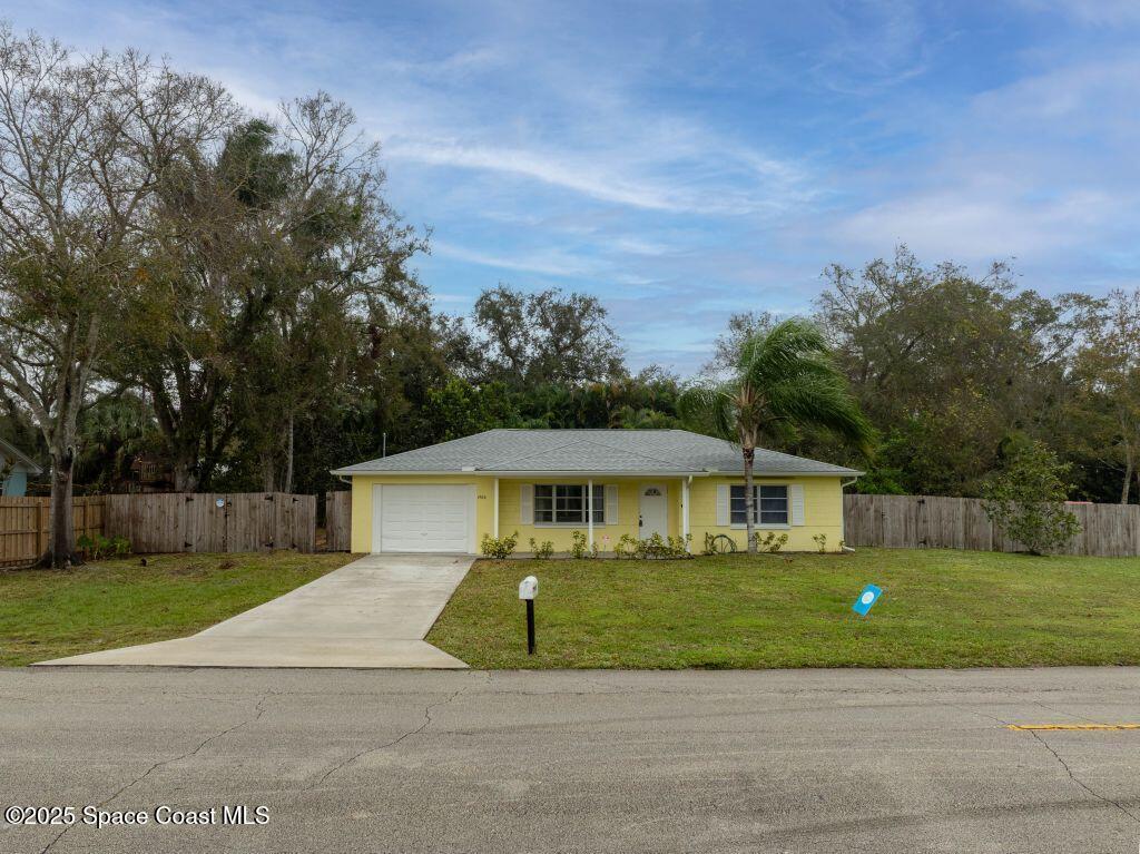 ranch-style home featuring a garage and a front lawn