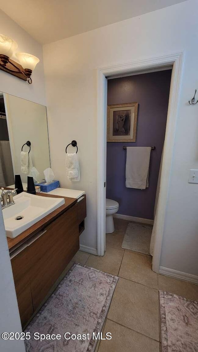 bathroom featuring vanity, tile patterned floors, and toilet