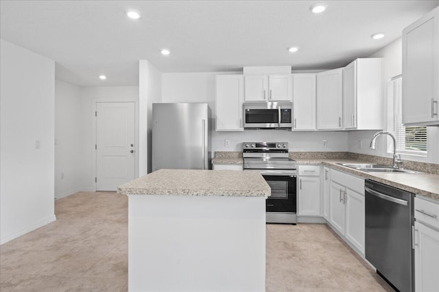 kitchen featuring white cabinetry, stainless steel appliances, sink, and a kitchen island