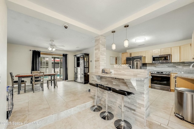 kitchen with pendant lighting, a breakfast bar area, decorative backsplash, kitchen peninsula, and stainless steel appliances