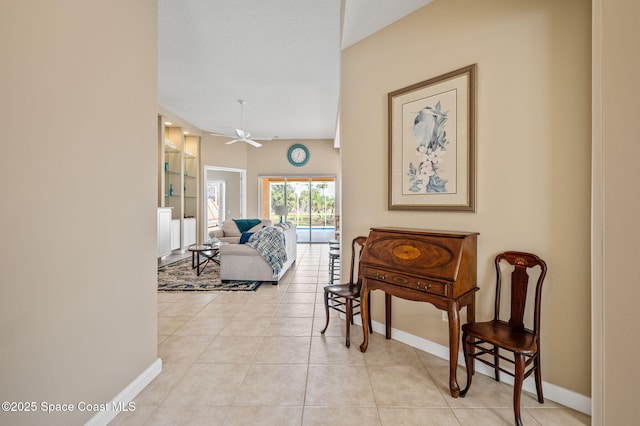 corridor featuring light tile patterned flooring, built in features, and a textured ceiling