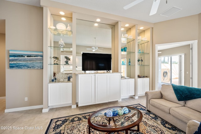 living room featuring light tile patterned floors and ceiling fan