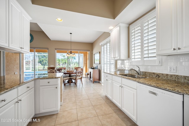 kitchen featuring white cabinetry, white dishwasher, sink, and dark stone countertops