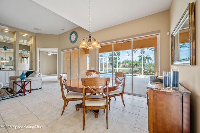 tiled dining area featuring ceiling fan with notable chandelier