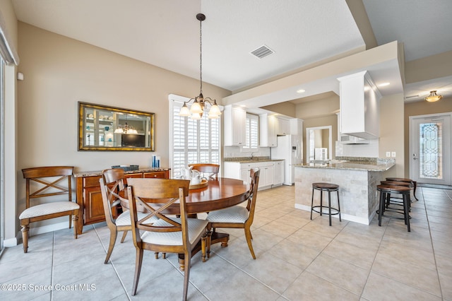 tiled dining space with a wealth of natural light and a notable chandelier