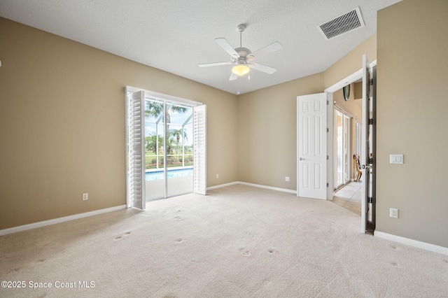 carpeted empty room featuring a textured ceiling and ceiling fan