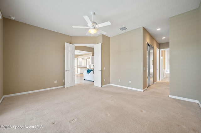 carpeted spare room featuring ceiling fan