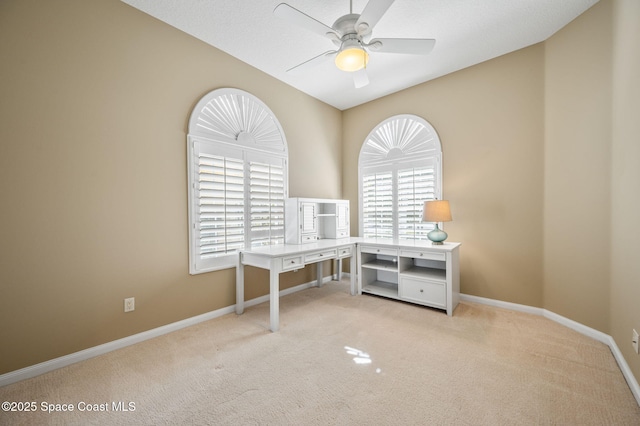 carpeted office featuring ceiling fan