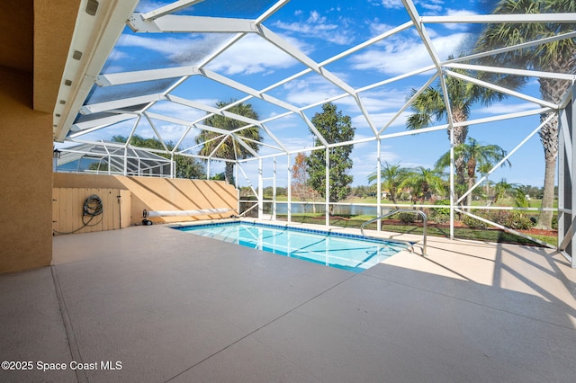 view of pool featuring a patio, a water view, and glass enclosure