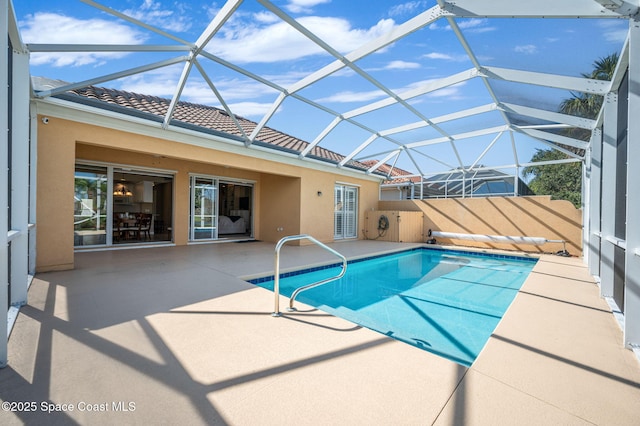 view of swimming pool featuring a patio area and glass enclosure