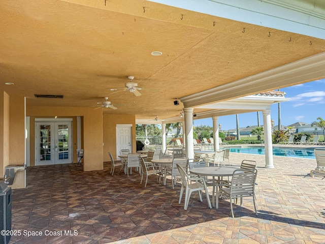 view of patio / terrace featuring a community pool, ceiling fan, and french doors