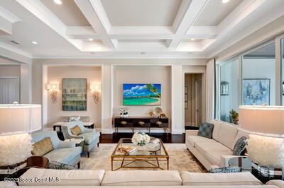 living room with coffered ceiling, beam ceiling, and light hardwood / wood-style flooring