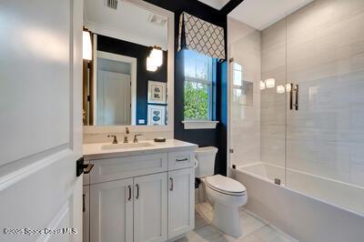 full bathroom with tiled shower / bath, vanity, and toilet