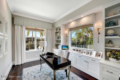 office with dark hardwood / wood-style flooring and built in shelves