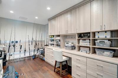 home office featuring dark hardwood / wood-style floors and built in desk